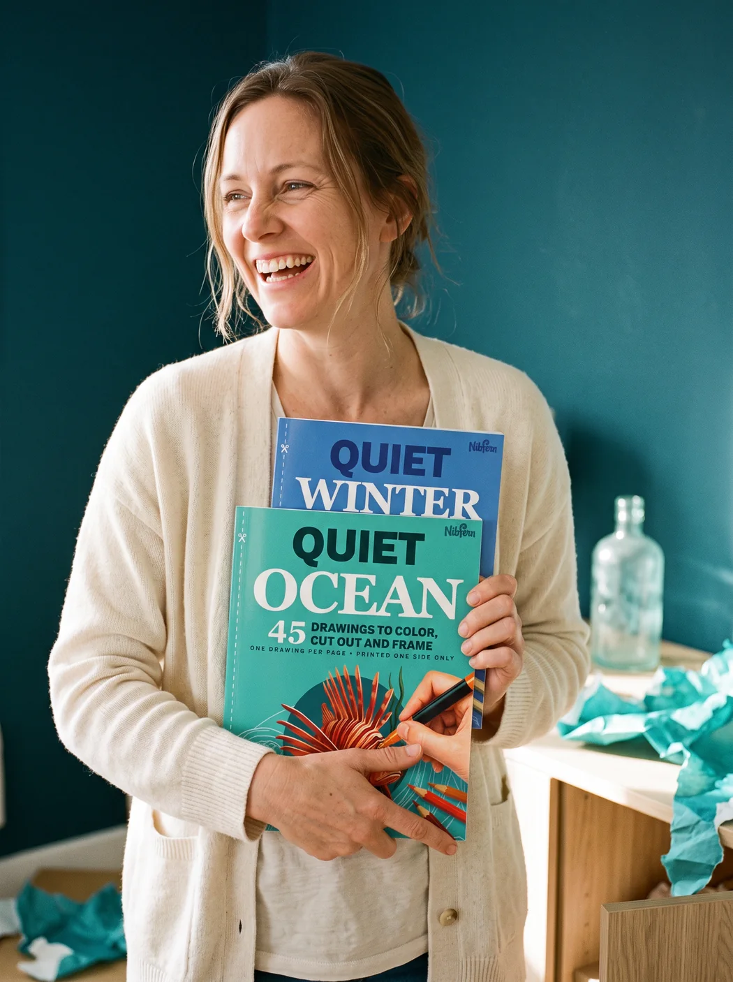 A woman smiling and hugging Quiet Ocean and Quiet Winter to her chest