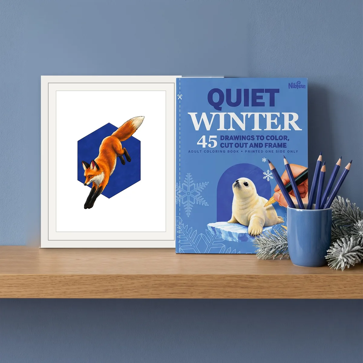 A framed red fox page beside a copy of Quiet Winter on a shelf